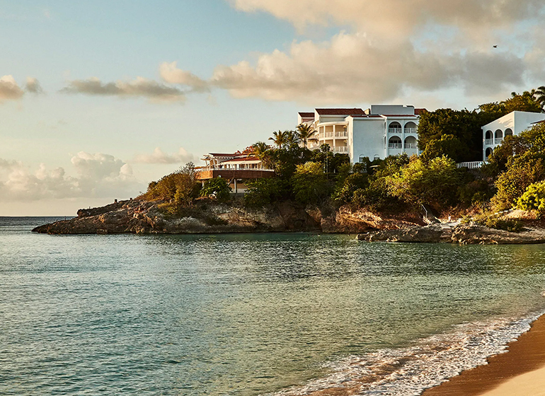 Malliouhana Resort by Auberge view from beach building on rocks